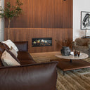 Modernt vardagsrum med ruffiga inslag – mörka soffor, en fluffig matta och en fondvägg klädd i oljad ekpanel från Wood on Wall.